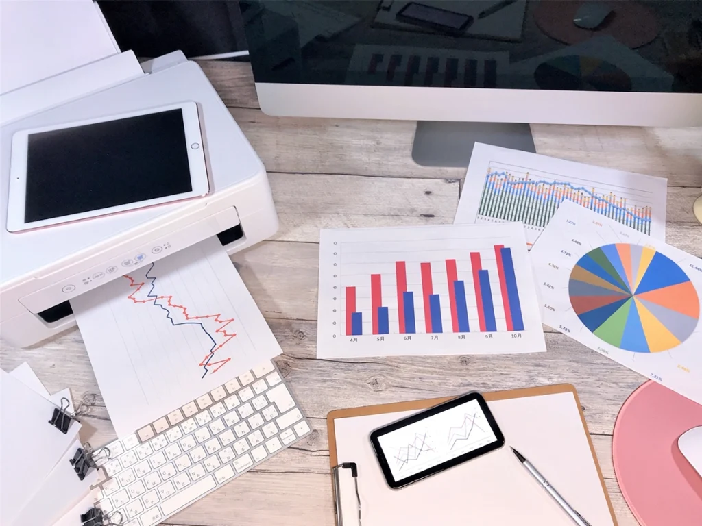 経営者いらずの経営推進室の支援イメージ。デスクの上に業績資料や業務整理の書類が並ぶ様子